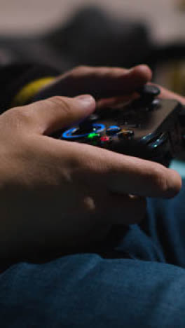 Vertical-Video-Close-Up-Hands-Man-Playing-Video-Game-Controller-Sitting-Sofa-At-Home